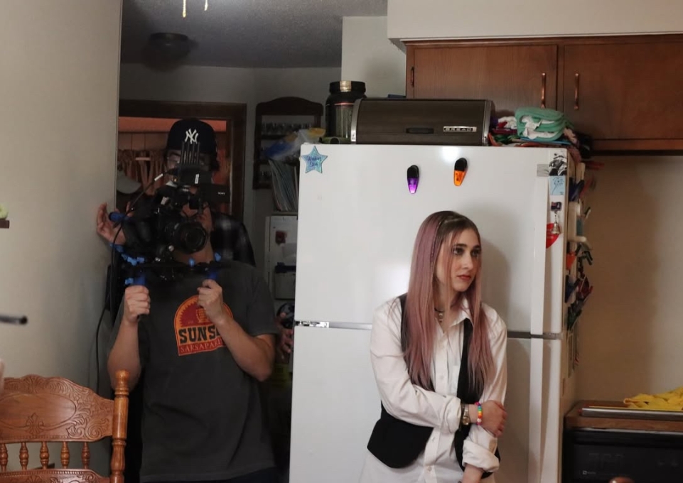 Student holding camera and student actor in scene